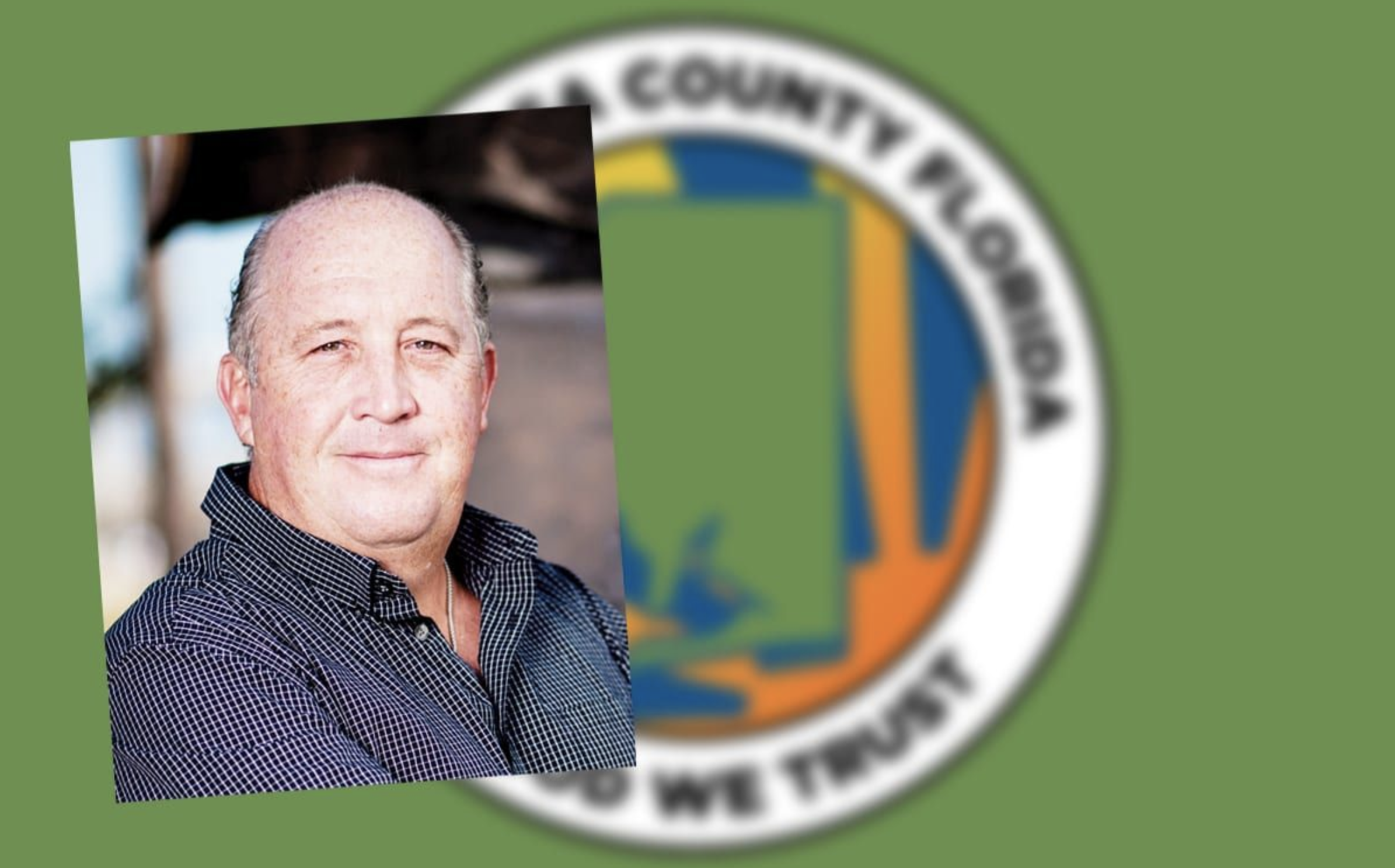 A county commissioner in front of the Santa Rosa County crest
